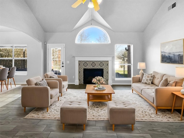 living room with a fireplace, vaulted ceiling, and ceiling fan