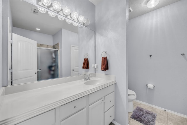 bathroom with an enclosed shower, vanity, tile patterned floors, and toilet