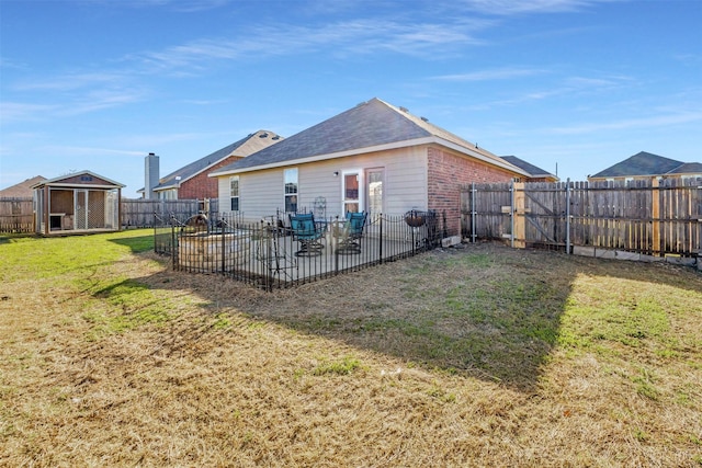 back of house with a yard, a patio area, and an outdoor structure