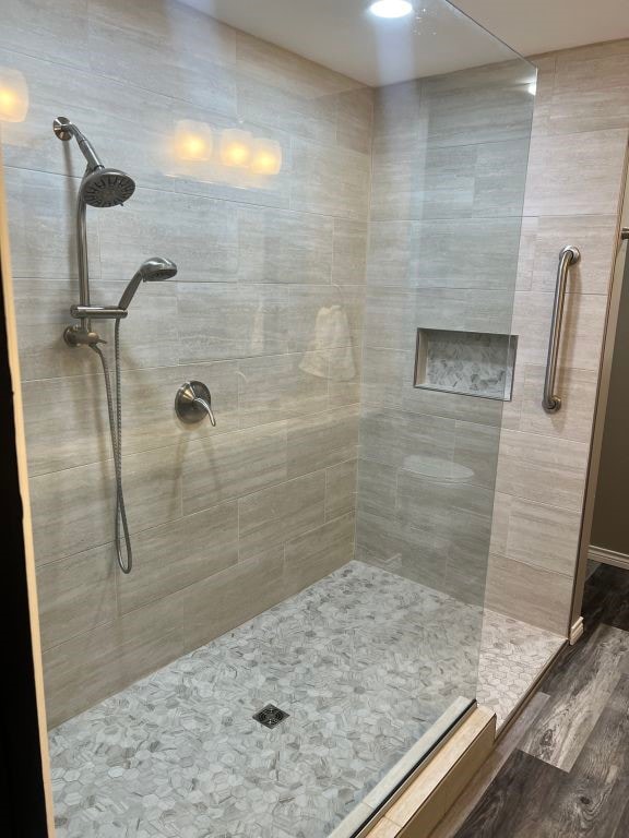 bathroom featuring a tile shower and hardwood / wood-style floors