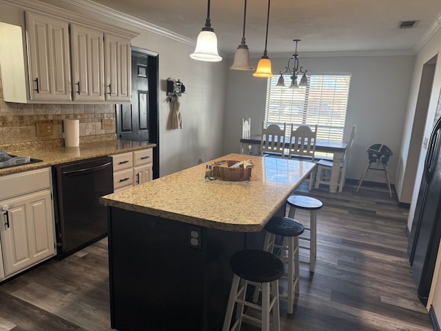 kitchen featuring pendant lighting, dishwasher, a center island, tasteful backsplash, and ornamental molding