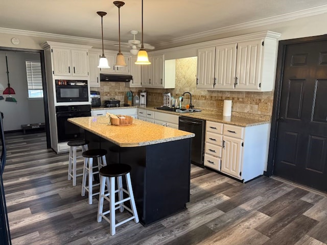 kitchen with hanging light fixtures, sink, white cabinets, a kitchen island, and black appliances