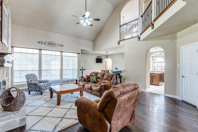 living room with high vaulted ceiling, wood-type flooring, ceiling fan, and a fireplace