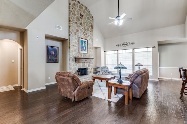 living room featuring high vaulted ceiling, dark hardwood / wood-style flooring, ceiling fan, and a fireplace