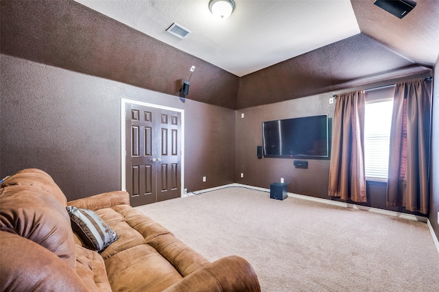 home theater room featuring vaulted ceiling and carpet flooring