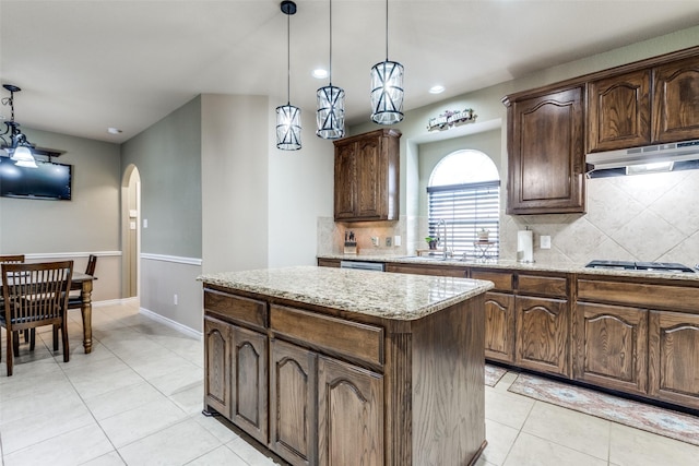 kitchen featuring appliances with stainless steel finishes, a kitchen island, sink, hanging light fixtures, and light tile patterned floors