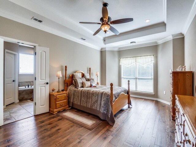 bedroom with crown molding, dark wood-type flooring, a tray ceiling, and ceiling fan