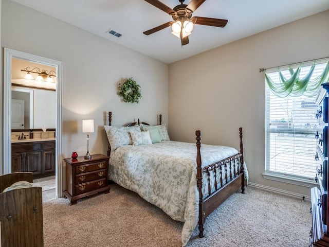 carpeted bedroom featuring sink, ceiling fan, and ensuite bath