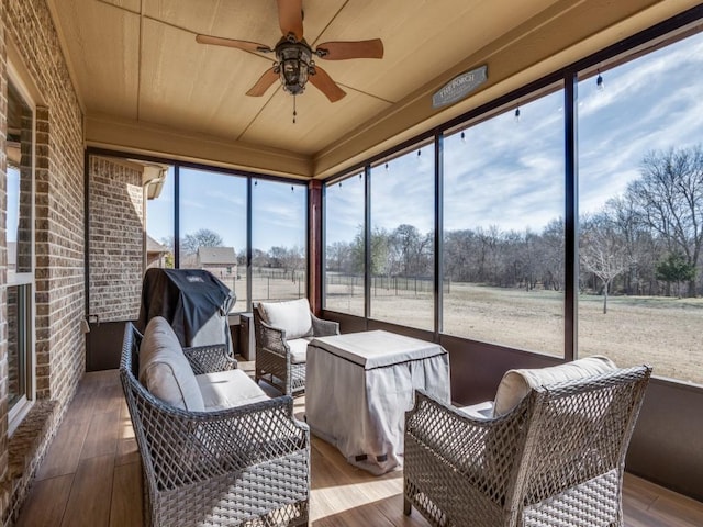 sunroom with ceiling fan and wooden ceiling