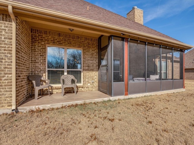 rear view of house with a wooden deck and a sunroom