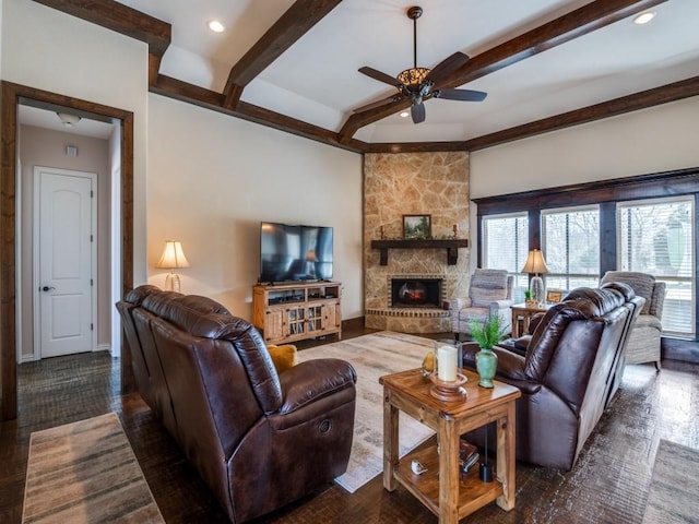 living room featuring ceiling fan, dark hardwood / wood-style floors, beamed ceiling, and a fireplace