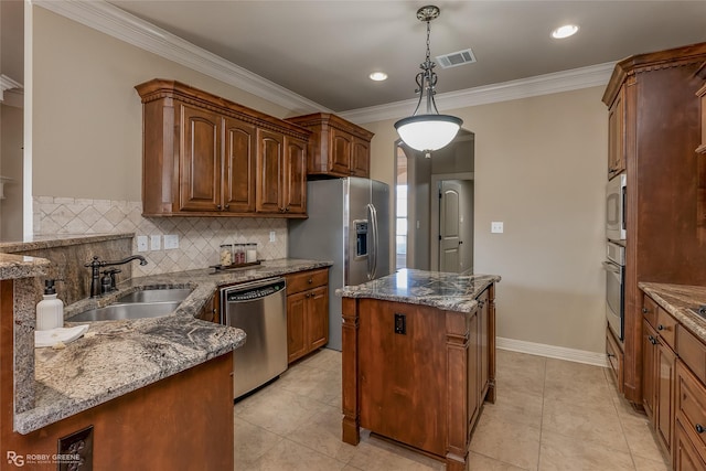 kitchen featuring appliances with stainless steel finishes, pendant lighting, sink, dark stone counters, and a center island