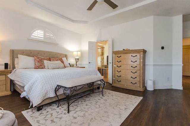 bedroom featuring ceiling fan, a raised ceiling, and dark hardwood / wood-style flooring