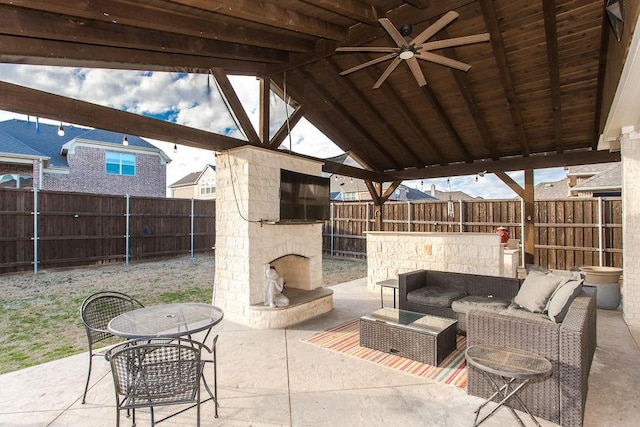 view of patio / terrace with an outdoor living space with a fireplace and ceiling fan