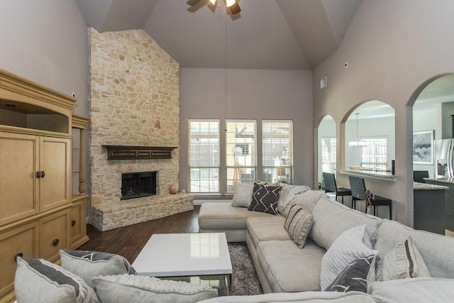 living room featuring ceiling fan, high vaulted ceiling, dark hardwood / wood-style floors, and a fireplace