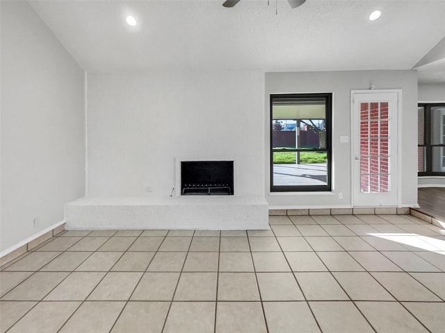 unfurnished living room featuring light tile patterned floors and ceiling fan