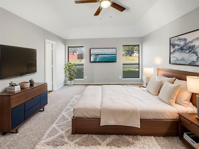 carpeted bedroom featuring ceiling fan and a raised ceiling