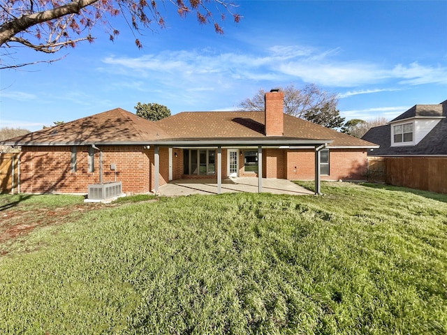 rear view of house featuring a patio, a yard, and central AC