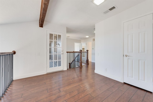 empty room with beamed ceiling and dark hardwood / wood-style floors