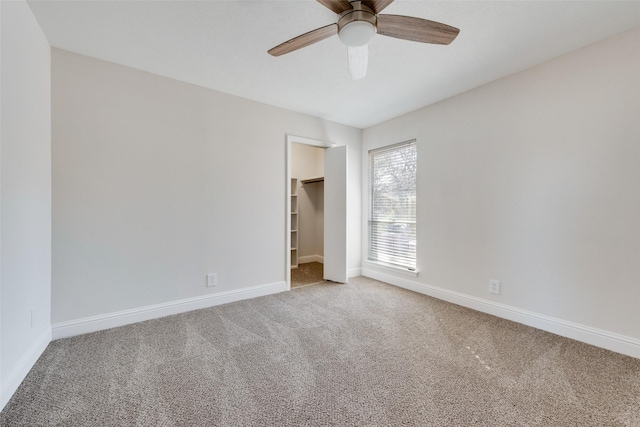 unfurnished bedroom with a walk in closet, ceiling fan, carpet flooring, and a closet