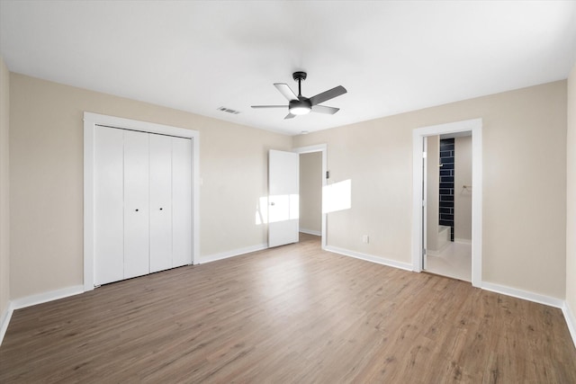 unfurnished bedroom with ceiling fan, wood-type flooring, and a closet