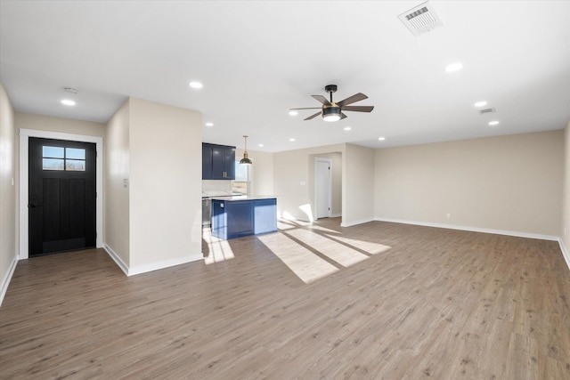 unfurnished living room with ceiling fan and wood-type flooring