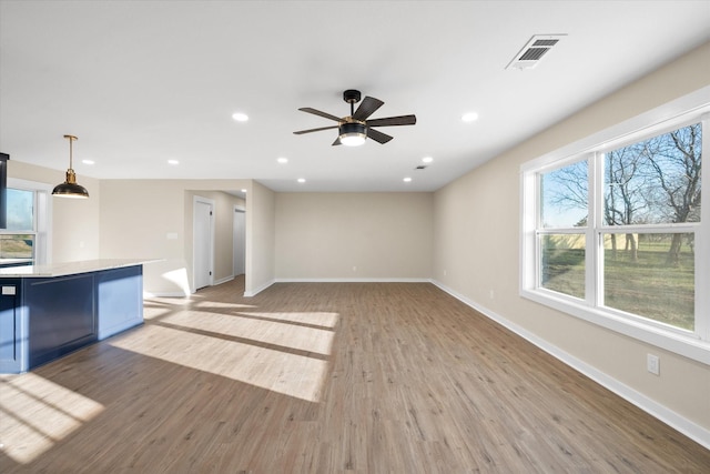 unfurnished living room with ceiling fan and light hardwood / wood-style flooring