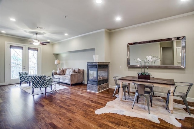 dining room featuring wood-type flooring, french doors, a multi sided fireplace, ornamental molding, and ceiling fan