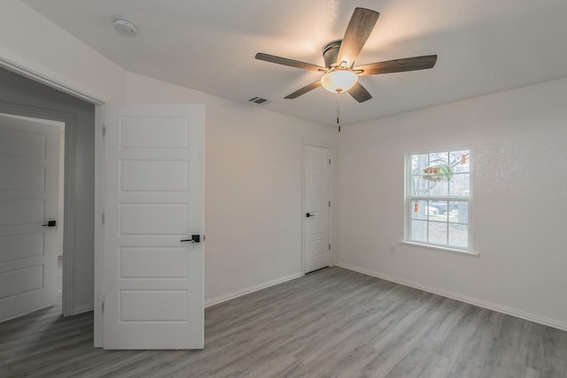 spare room with hardwood / wood-style flooring and ceiling fan