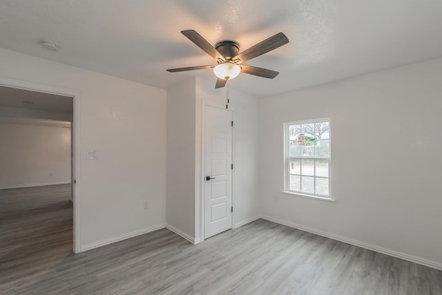 unfurnished bedroom with ceiling fan and light wood-type flooring