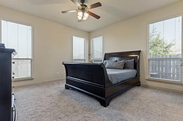 bedroom featuring ceiling fan, carpet, and multiple windows