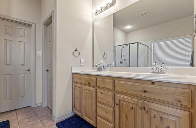 bathroom featuring tile patterned flooring, a shower with shower door, and vanity