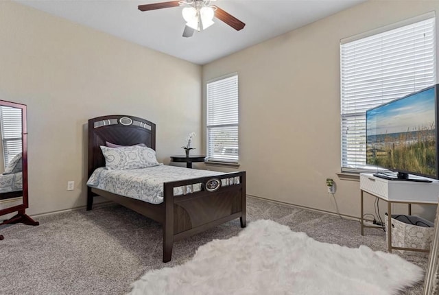 bedroom with ceiling fan, light colored carpet, and multiple windows