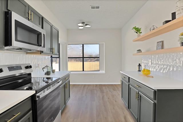 kitchen featuring light hardwood / wood-style flooring, appliances with stainless steel finishes, and gray cabinetry