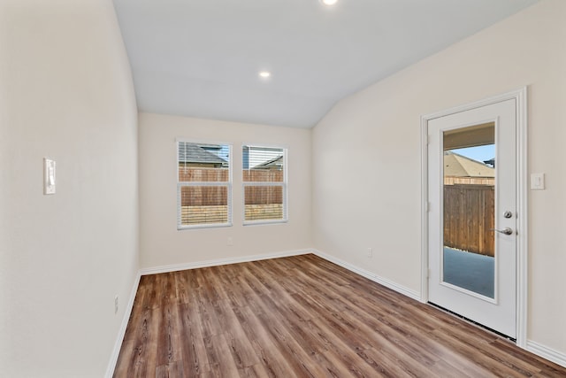 empty room featuring light hardwood / wood-style flooring and vaulted ceiling