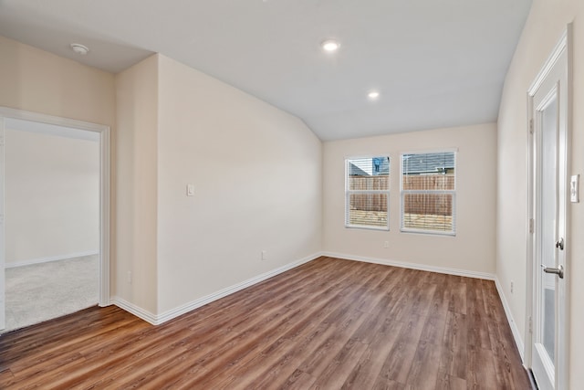 spare room with hardwood / wood-style flooring and lofted ceiling