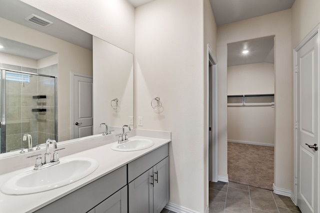 bathroom with vanity, a shower with shower door, and tile patterned floors