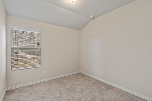 carpeted spare room featuring lofted ceiling