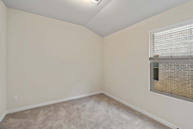 carpeted spare room with lofted ceiling