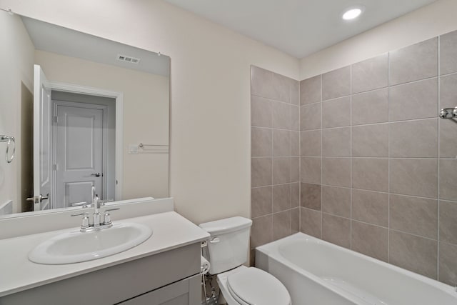 full bathroom featuring toilet, tiled shower / bath, and vanity