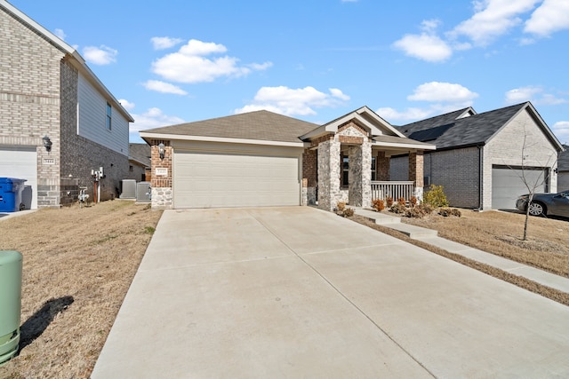 view of front of house featuring covered porch, central AC unit, and a garage