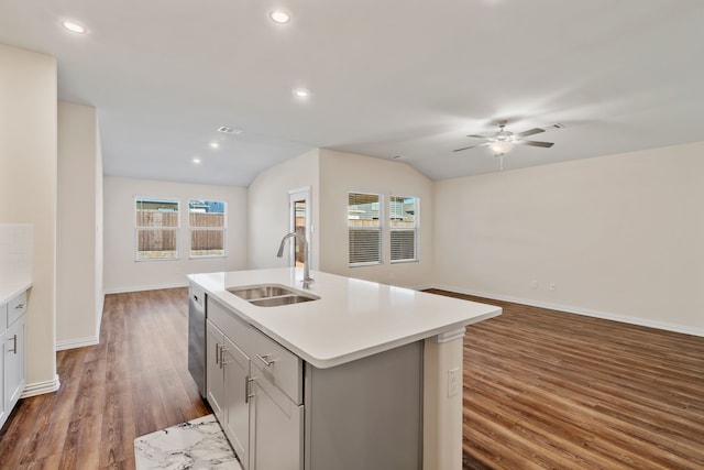 kitchen with dishwasher, sink, dark wood-type flooring, a kitchen island with sink, and lofted ceiling