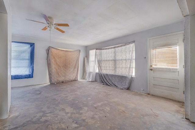 empty room featuring ceiling fan and concrete floors