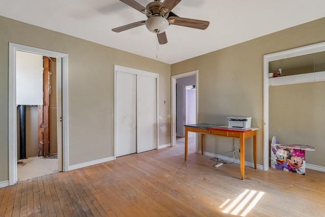 home office with light wood-type flooring and ceiling fan