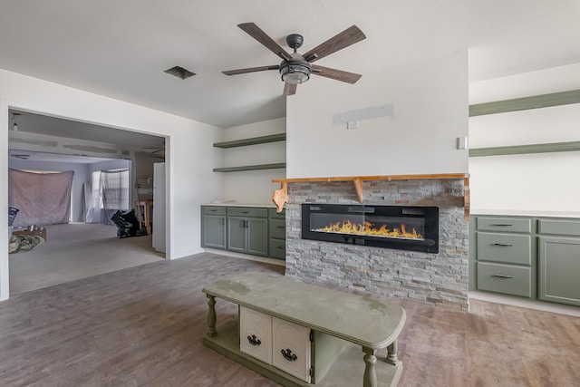 living room with wood-type flooring, a fireplace, and ceiling fan