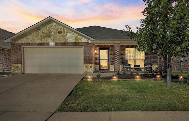 view of front of property with a garage and a lawn