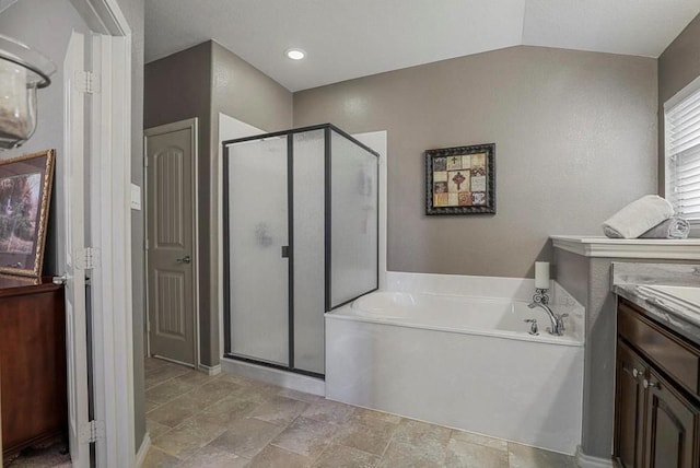 bathroom featuring vanity, independent shower and bath, and vaulted ceiling