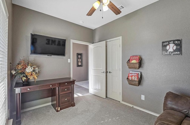 carpeted home office with ceiling fan