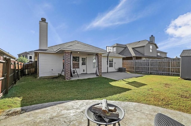 back of property with an outdoor fire pit, a lawn, and a patio