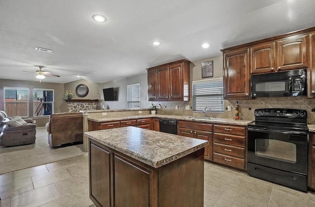 kitchen with black appliances, a kitchen island, sink, kitchen peninsula, and ceiling fan